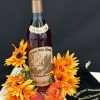 Pappy Van Winkle 23 year old bourbon bottle surrounded by flowers.