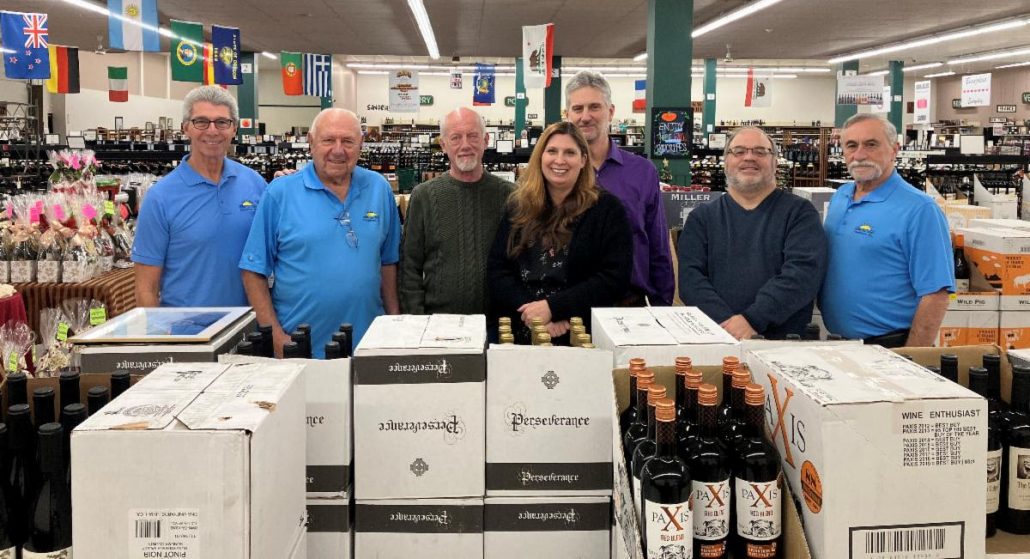 Group photo with HOPE for Youth Foundation board members and Viscount Wines and Viscount Wine and Spirits staff. All are standing behind a table of wine bottles and cases.