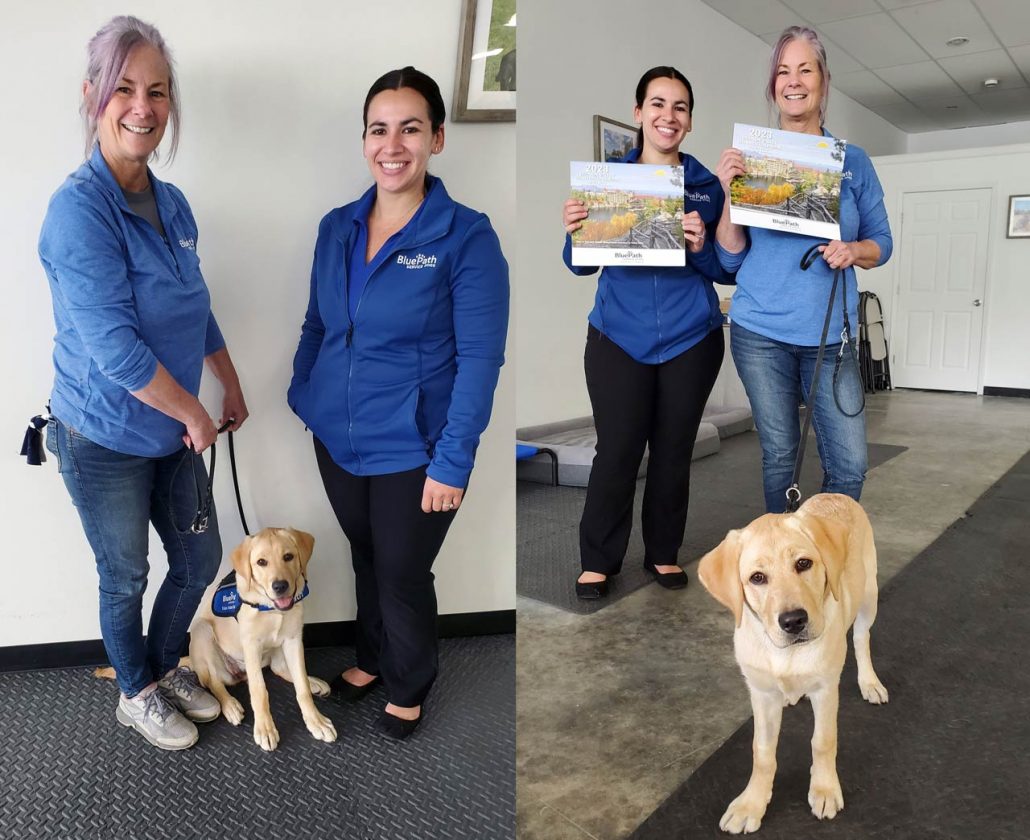 Two BluePath female employees holding HOPE for Youth calendars. Puppy labrador named Hope is in front.